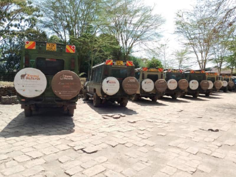 Safari vehicles with Kwezi Safaris branding for game drives and adventures.